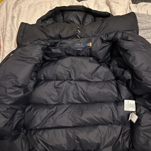 Polo Ralph lauren jacka - Vinterjacka av märket Ralph lauren köpt från butiken i NK under vintern, använd i drygt 2 månader gillade ej storleken och säljer därför den. Bevis är QR kod kopplad direkt till modellen. 