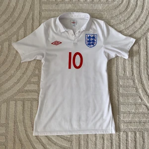 ENGLAND FOTBOLLSTRÖJA  - ORIGINAL ENGLAND HEMMA/ 2010 Wayne Rooney #10  STORLEK: S PRIS: 449 SEK   OBS! Produkten stryks innan den fraktas iväg. Vid köp eller funderingar kontakta oss.   Instagram: @beyondthekits EJ REPLIKA #england#umbro#rooney