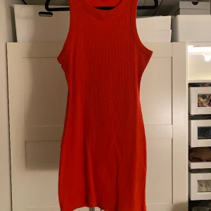 Röd minidress - Röd tajt ribbad armlös klänning. Använd en gång men perfekt till fest.