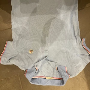 Moncler ljus blå pike  - En Moncler piké nästan helt nytt i färgen ljus blå med storleken medium. Priset kan diskuteras om snabb äffar