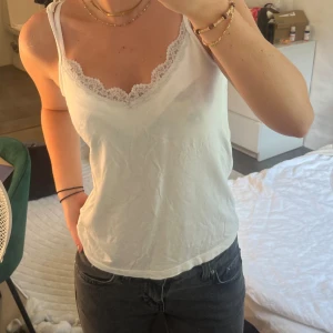 Vitt linne med spets - Vitt linne med spets, v-ringad. Storlek M ifrån Lager 157. Nopprig på insidan av tröjan men fint skick på utsidan!❤️