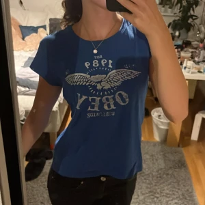 Blå topp - Obey replika med coolt tryck. Använd ett fåtal gånger.🌟