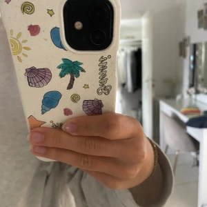 Ganni mobilskal - Superfint och somrigt mobilskal från Ganni, köpt direkt från deras hemsida för något år sedan. Använt med i gott skick, passar iPhone 12. Går att förhandla om priset!