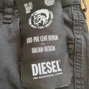 Svarta jeans från Diesel - Svarta jeans från Diesel med knappgylf och regular waist. Modellen heter Babhila och har en slim skinny passform.