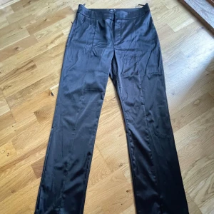 Satinbyxor med slits - Raka/utsvängda byxor i satin. Rejält och bra tyg. Endast provade men tyvärr aldrig använda.