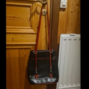 Vintage läder väska🍷 - Vintage väska i äkta läder med röda detaljer, i acceptabelt men smått slitet skick! (Fixar bilder om så önskas!) Säljes då jag samlat på mig alldeles för många väskor och är i akut behov av plats😭😔