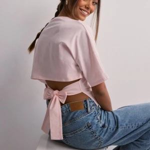 Open back tie tee  - Intressekoll!! Denna fina otroligt populära  t-shirten funderar på att sälja, skriv jätte gärna hur mycket ni skulle kunna lägga så tar vi det därifrån💗💗💗 den är i väldigt bra skick ( den är helt slutsåld på Nellys hemsida )