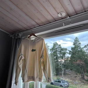 Kräm vit hoodie från Danmark - Helt nyskick, knappt använd. Den passar perfekt för mig som är 184cm lång.  Den har lite halv tunt tyg perfekt för vår och höst.