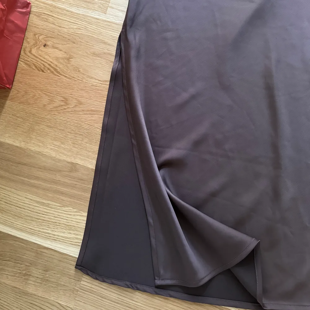 En brun midikjol i satin. Kjolen kommer ifrån Bikbok och är knappt använd, köpt förra året. Har en liten slits vid ena sidan. Längden på den är 90cm.. Kjolar.