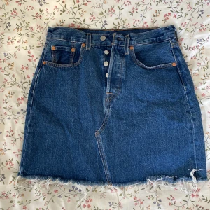 Jeanskjol  - Jättefin jeanskjol från Levis i superbra skick! Storlek 27 och midjemått ca 37 x2.  Skulle gå att klippa kortare om man vill! Säljer pga för liten 💗