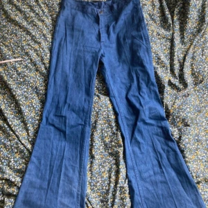 utsvängda jeans  - skitsnygga utsvängda och högmidjade jeans från 70-talet. köpta på en vintagemarknad i london i somras för 600kr. i väldigt bra skick. det står storlek 34 i byxorna men de är större. midjemått rakt över: 41cm innerbenslängd: 79cm