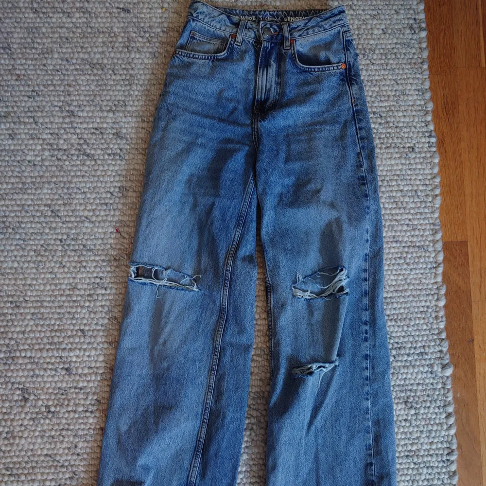 Ripped jeans från Bikbok. Använd men i bra skick. Säljer för den sitter tajt från höften. Färgen är mörkare blå. Storlek: 24 midja och 32 i längd.. Jeans & Byxor.