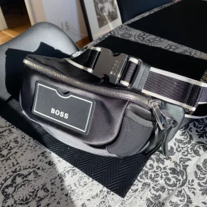Boss axelväska (knappt använd) - Hugo boss axelväska köpt sommaren 2022 från boss hemsida för 1700 kr men knappt använd. Väskan är äkta och kvitto/orderbekfräftelse finns även.