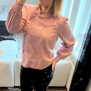 Blus - Babyrosa blus med knappar hela vägen så man kan själv bestämma hur öppen den ska vara. 