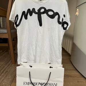 Helt ny äkta Emporio Armani T-shirt. Köpt på Emporio Armani för ca 1500 kr. Säljer på grund av att den är för liten på mig. Storlek S. Alla lappar är kvar förutom prislappen, eftersom jag fick den i present. För att kolla äktheten så scannar du QR.