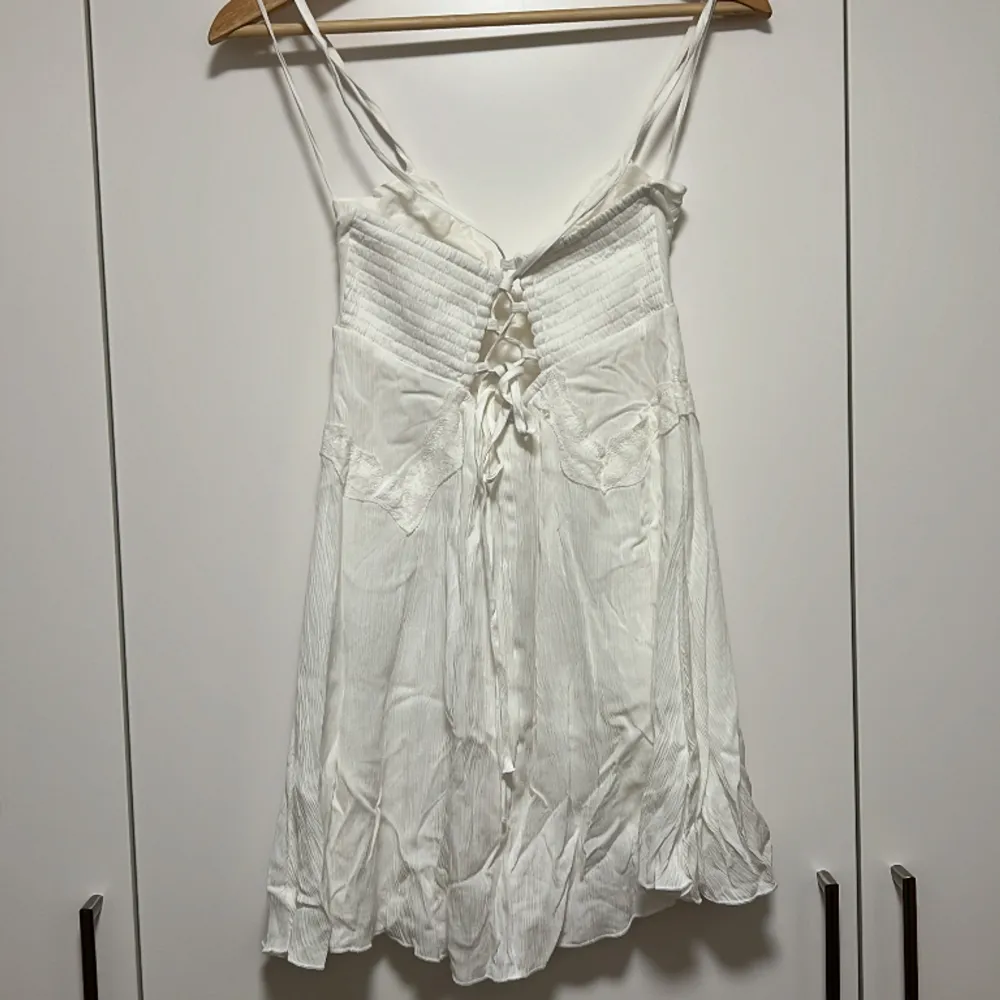 Söt klänning från Stradivarius med korsad rygg och knytdetalj. Aldrig använd då den är för kort för mig (170 cm). Klänningar.
