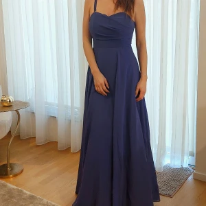 Balklänning - Superfin lila balklänning i märket Rut&Circle. Den är egentligen i storlek 34 men blixtlåsen ersattes med rosetter i ryggen för att passa storlek 34 och 36. Den går att sy tillbaka till blixtlås.