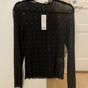 Svart mesh topp med paljetter  - Aldrig använd , från ginatricot och lappen sitter fortfarande kvar.