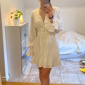 Vit klänning - Storlek 38 från Na-kd. Ny med lappen kvar! Köpte denna för att ha på studenten, men den är tyvärr lite för stor för mig 🥲Verkligen så fin och perfekt för student, skolavslutning eller midsommar 🌸 Slutsåld på hemsidan