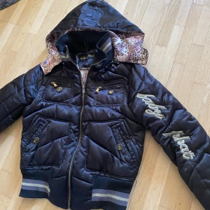 Baby phat jacka - Jättefin svart baby phat jacka! Fortfarande i jättebra skick. Står ingen storlek. Ganska liten dock, för referens är jag runt 158 i sista bilden och bär ofta xs-s och den sitter lite stort. Uppskattar till S och kan passa M. Luvan är avtagbar!