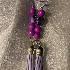 Lila Örhängen med dödskallar  - Cerise/lila örhängen med dödskallar. Använda enstaka tillfälle. 