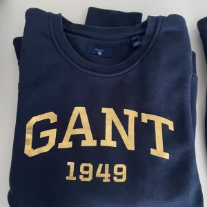 Gant collegetröja - Str s. Nyskick. Mörkt blå med Guld. 