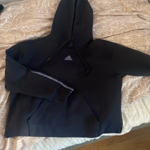 Adidas tröja - Säljer denna tröja pga den bara har användts ungefär 3-4 ggr pga jag inte tycker om den🩷 Den hår en slit där nere vilket är superfint. Storlek M . Materialet är tjockt och skönt. Inte säker på nypris men tror det var runt 250-300 så säljer för 150kr.