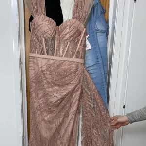 Fest/balklänning - Säljer en champagne rosa klänning i storlek 44. Super fin på kroppen o går att ha på axlarna, off shoulders och mittimellan.  Använt en gång (Andra bilden är till som exempel på hur det ser ut, av modellen) Pris kan diskuteras 