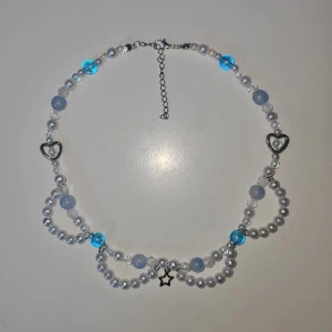 Handgjort halsband - Handgjort halsband av mig i blått och vitt. Halsbandet är gjort med mesta dels plast pärlor men också några glas pärlor. 