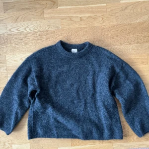 H&M oversized tröja i mohairmix - Sjukt snygg och slutsåld stickad mohair tröja från H&M. Använd fåtals gånger så är i väldigt bra skick! Är i mörk grå färg! Nypris 700 kr!