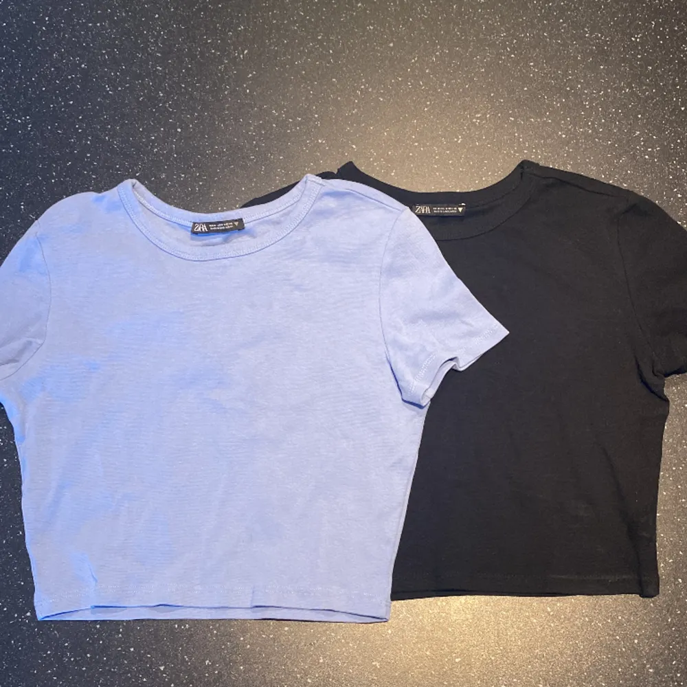 2-pack croppde t-shirts i ljusblått och svart. Sparsamt använda. (Legat i garderoben ett tag, därför rensas). Toppar.