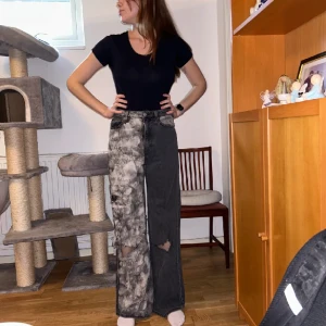 Jeans med tryck - Modellen är 175 cm långoch brukar ha storlek 38/S. Köpta här på Plick, förra säljaren gjorde designen själv. Använda 2 gånger. På framsidan av benet är en lista på hela MBDF albumet av Kanye West och på baksidan DSP av Big Sean