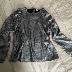 Silvrig blus  - En fin silvrig blus. Knappt använd. 