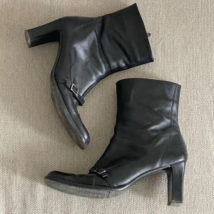 Svart läder boots med spänne - Snygga i storlek 41 men liknar mer en 39-40. Jag har 39 och dom passar bra på mig. Super snygga vintage