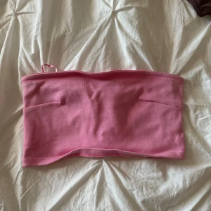 Rosa tubtopp från Gina Tricot - En enkel och stilren rosa tubtopp från Gina Tricot. Toppen är ärmlös och har en tight passform, perfekt för sommarens varma dagar.