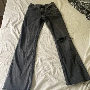 säljer dessa mid waist straight jeans med ett hål knäet från gina tricot i storlek 34