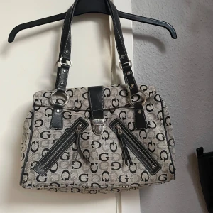 GUESS Väska - min mammas väska från 2000’s, inga tecken på användning för utom en liten fläck inuti väskan som inte går bort. 