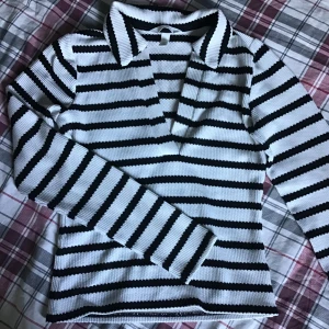 H&M tröja - Randig svart off-white H&M tröja med krage. Tröjan har använts få gånger och är i väldigt bra skick.