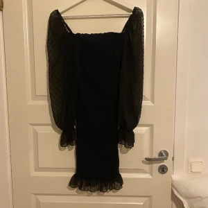 Klänning - klänning som aldrig är använd med genomskinligt material på ärmarna. Storlek XS, passar S och M också