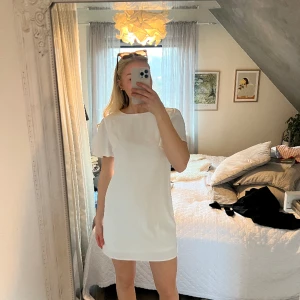 Vit klänning  - Kort vit klänning från Nelly med snygg öppning i ryggen. Har ett litet märke på ärmen som säkert går att tvätta bort🤍 perfekt studentklänning! 