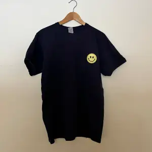 Stor t-shirt från fruit of the loom med en fast struken smiley i jättebra skick!! Marinblå 