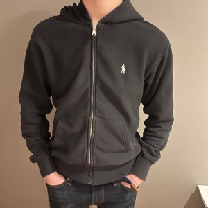 Ralph lauren zip - Säljer min  Ralph lauren zip. Den är svart med vita snören. Skick 9,5/10. Använd ca 4 gånger. Den har inga defekter o passar folk mellan 160-170. Modellen på bilden är 170