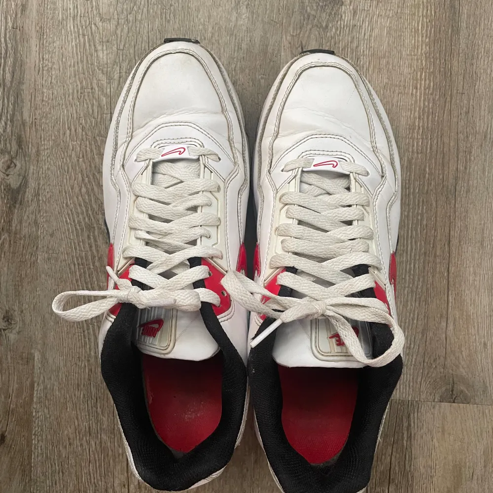 Nike air Max sneakerskor, storlek 43. Skorna är i använt skick. Färg röd, svart och vit med detaljer. Kommer inte med originalboxen. Prutning är möjligt. Frakt är möjligt men också avhämtas. Kontakta mig för mer bilder och ytligare mer information.. Skor.