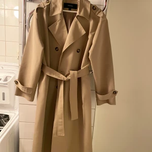 Ny trenchcoat - Helt ny trench coat från Vero Moda, använd endast en gång så den är precis som ny. Storlek S, finns i Göteborg :)