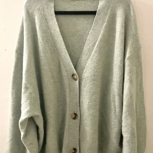 KOFTA MED KNAPPAR - Mint färgad kofta med v-nacke,vida ärmar och knappar i nyanser av ljusgrön/mint. Strl XL stretchig med mjukt tyg. Använd fåtal gånger, skick som ny. 