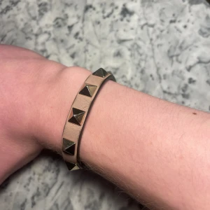 Valentino armband  - Ett beiget Valentino armband i bra skick. Givetsvis äkta. Några defekter som inte märkts när man bär det. Passar både killar och tjejer bra. Endast armbandet medföljer. Vid frågor ”kontakta”📩