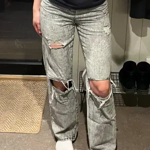 Ett par gråa jeans i storlek 36. Modellen på dessa är straight. Skulle säga att de är ganska high-waist. Även dessa har hål vid knäna som ger en lite street-ig look. Ganska väl använda men i bra skick. Litet hål mellan benen, men syns ej när de är på