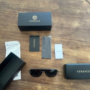 Äkta versace solglasögon - Köpta förra året i april för 2850kr på NK i Göteborg. Säljer dom nu i kanon skick inga defekter då jag köpt nya glasögon. Alla original tags samt lådor som medföljde finns kvar. Även kvittot från NK