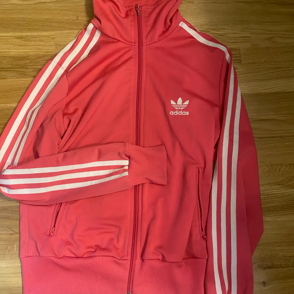 Rosa adidas hoodie skick 8/10 då den har två fläckar se på bild 5 en grå vid armvecket och en vid arm mudden men dem är nästan omärkbara storlek M/L men passar mig som vanligt vis har S. Hoodies.