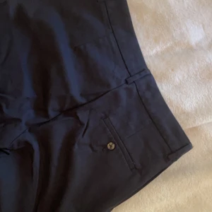  kostymbyxor - Svarta kostymbyxor med knapp. Relativa lågmidjade då de är storlek xs. Passar mig som bär S och är ca 164. (OBS: Söndrig kamera därav de suddiga bilderna)